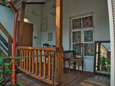 a wooden porch with a table and stained glass windows at Stylish & Comfortable 1-Bedroom Apartment in Vilnius Old Town by URBAN RENT in Vilnius