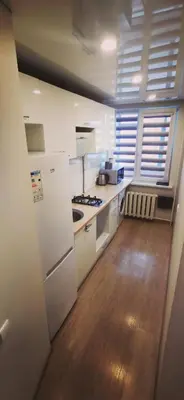 a kitchen with white appliances and a wooden floor at Lauros 1 & R Apartamentai in Panevėžys