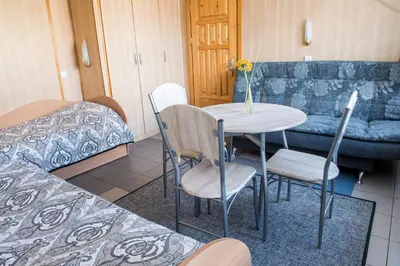 a room with a table and chairs and a couch at Eiva in Marijampolė