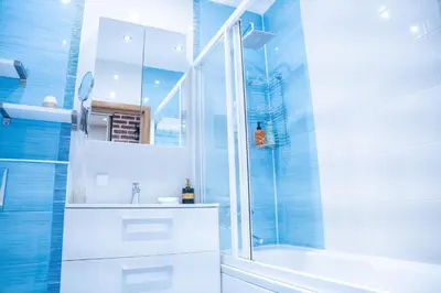a bathroom with a shower and a tub and a sink at Hygge Oasis for family with free parking and wi fi in Vilnius