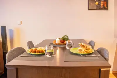 a wooden table with two plates of food on it at Hygge Oasis for family with free parking and wi fi in Vilnius