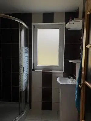 a bathroom with a window and a shower and a sink at Dzūkų sodžius in Snaigupė