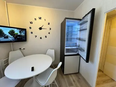 a room with a white table and a clock on the wall at AUKŠTAS Ap in Visaginas