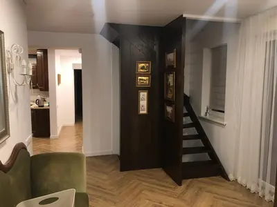 a living room with a staircase and a green couch at Wind Mood in Klebiškis