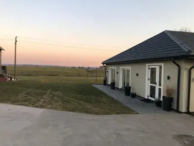 a house with a field in the background at Wind Mood in Klebiškis