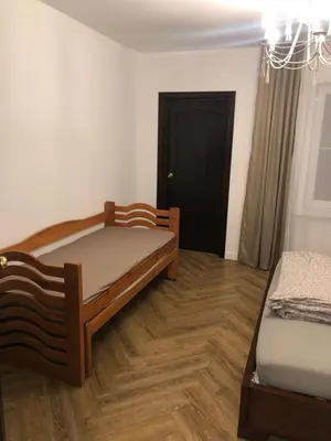 a bedroom with two beds and a black door at Wind Mood in Klebiškis
