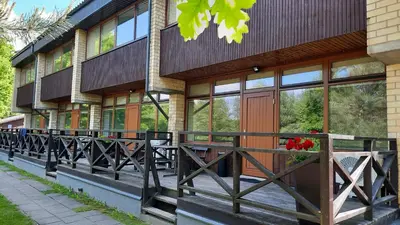 a building with a porch with flowers in a window at Kambarys Šiaurėje in Kaltanėnai