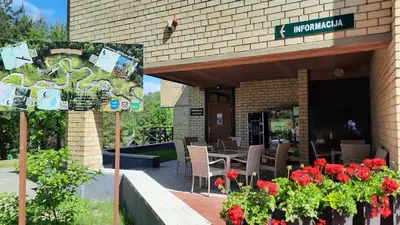 a restaurant with a table and flowers in front of it at Kambarys Šiaurėje in Kaltanėnai
