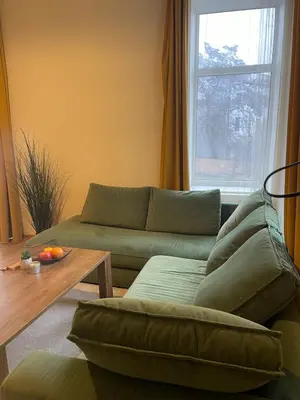 a living room with a couch and a table and a window at MM Apartments in Kaunas