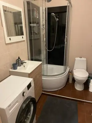 a bathroom with a toilet sink and a washing machine at MM Apartments in Kaunas