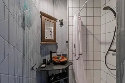a bathroom with a sink and a shower with a mirror at Old Town Hideaway in Vilnius