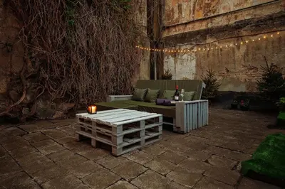a patio with a couch and a table and lights at Old Town Hideaway in Vilnius