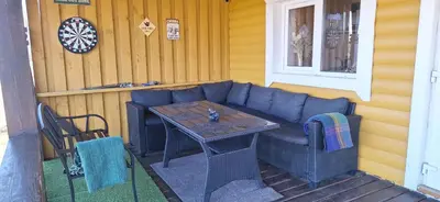 a patio with a blue couch and a table at Gėlūnų sodyba in Gelunai