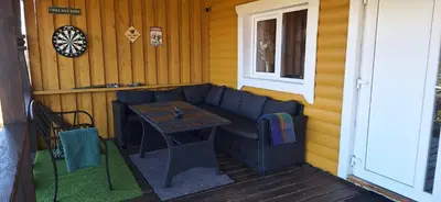 a patio with a couch and a table on a porch at Gėlūnų sodyba in Gelunai
