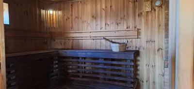 a sauna with a bucket on a wooden wall at Gėlūnų sodyba in Gelunai