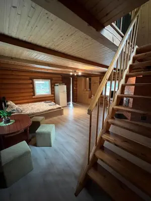a room with a staircase in a log cabin at Sekioniu Ranch - Cosy Wooden Cabins in Lithuania in Sekionys