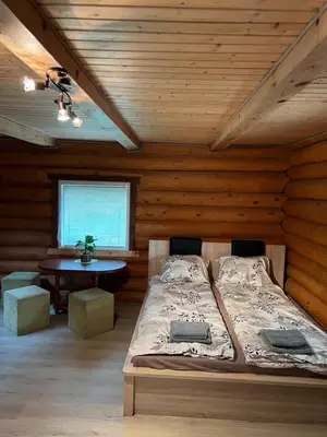 a bedroom with a bed in a wooden room at Sekioniu Ranch - Cosy Wooden Cabins in Lithuania in Sekionys