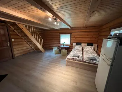 a room with two beds and a refrigerator in a cabin at Sekioniu Ranch - Cosy Wooden Cabins in Lithuania in Sekionys