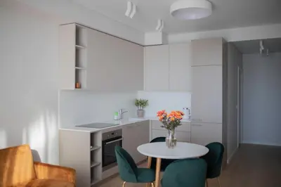 a kitchen with a table and some chairs and a counter at Parko Aveniu Apartamentai B2 in Birštonas