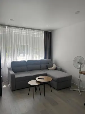 a living room with a blue couch and a table at AB Apartment in Marijampolė