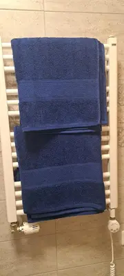 a pile of blue towels sitting on a towel rack at Vita apartment in Vilnius