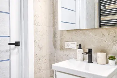 a bathroom with a white sink and a mirror at Old Town Edvin Apartments in Vilnius