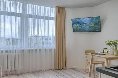a living room with a table and a large window at Old Town Edvin Apartments in Vilnius