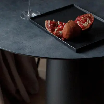 a black plate with a piece of pizza on a table at Spacious luxury apartment with parking in Vilnius