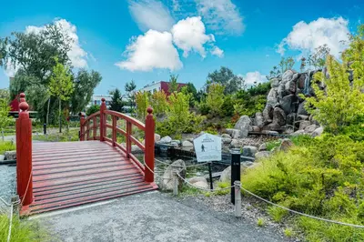 a red bridge over a pond in a park at Spacious luxury apartment with parking in Vilnius