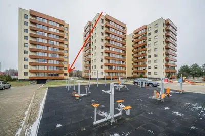 a parking lot with two tall apartment buildings at Erdvus triju kambariu butas, naujos statybos name in Kaunas
