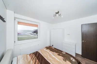 a bedroom with a bed and a window at Erdvus triju kambariu butas, naujos statybos name in Kaunas