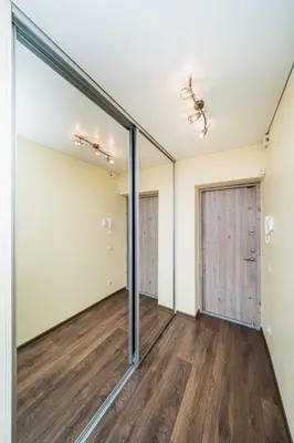 an empty room with sliding glass doors and wood floors at Erdvus triju kambariu butas, naujos statybos name in Kaunas