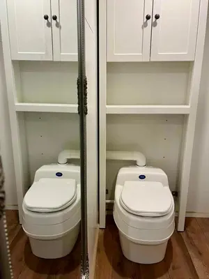 a bathroom with two toilets and white cabinets at Here & Now Tiny House in Sudvariškės