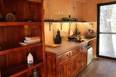 a kitchen with a wooden counter in a room at Here & Now Tiny House in Sudvariškės
