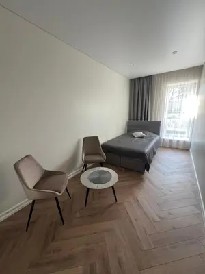 a bedroom with a bed and two chairs and a table at Sigita in Šveicarija