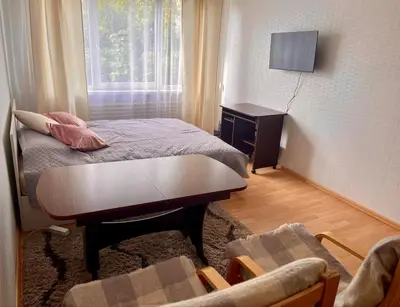 a small room with a bed and a table and a window at Apartment in the city Kaunas in Kaunas