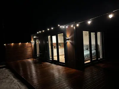 a room with a bed and lights on a deck at Spalvotas Beržas in Lyduokiai