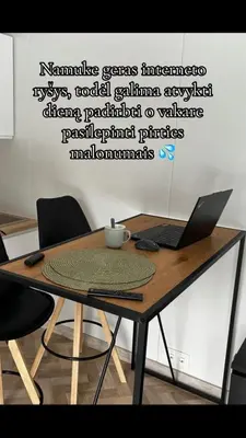 a wooden table with a laptop on top of it at Spalvotas Beržas in Lyduokiai