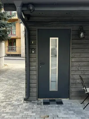 a blue door on a building with a window at Užupio apartamentai Nemokamas parkingas in Vilnius