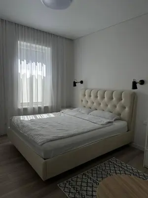 a large bed in a bedroom with a large window at Užupio apartamentai Nemokamas parkingas in Vilnius