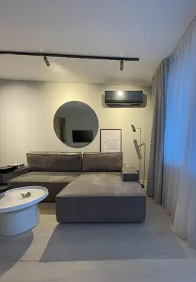 a living room with a couch and a mirror at Jaukus butas miesto centre in Šiauliai