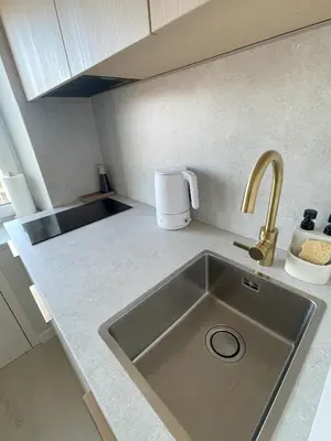 a kitchen counter with a sink and a coffee maker at Jaukus butas miesto centre in Šiauliai