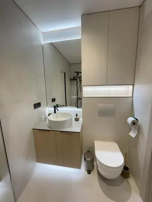 a white bathroom with a sink and a toilet at Jaukus butas miesto centre in Šiauliai