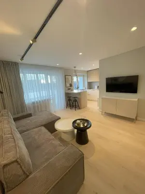 a living room with a couch and a tv at Jaukus butas miesto centre in Šiauliai
