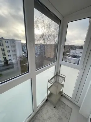 a empty room with three windows and a metal shelf at Jaukus butas miesto centre in Šiauliai