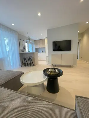 a large living room with a table and a tv at Jaukus butas miesto centre in Šiauliai