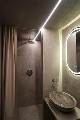 a bathroom with a sink and a shower with a mirror at K32 Loft in Vilnius