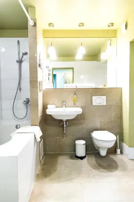 a bathroom with a sink and a toilet and a mirror at HOF Apartments in Kaunas