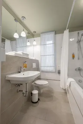 a bathroom with a sink and a toilet and a tub at HOF Apartments in Kaunas
