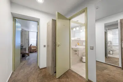 a hallway with a bathroom with a toilet and a sink at HOF Apartments in Kaunas